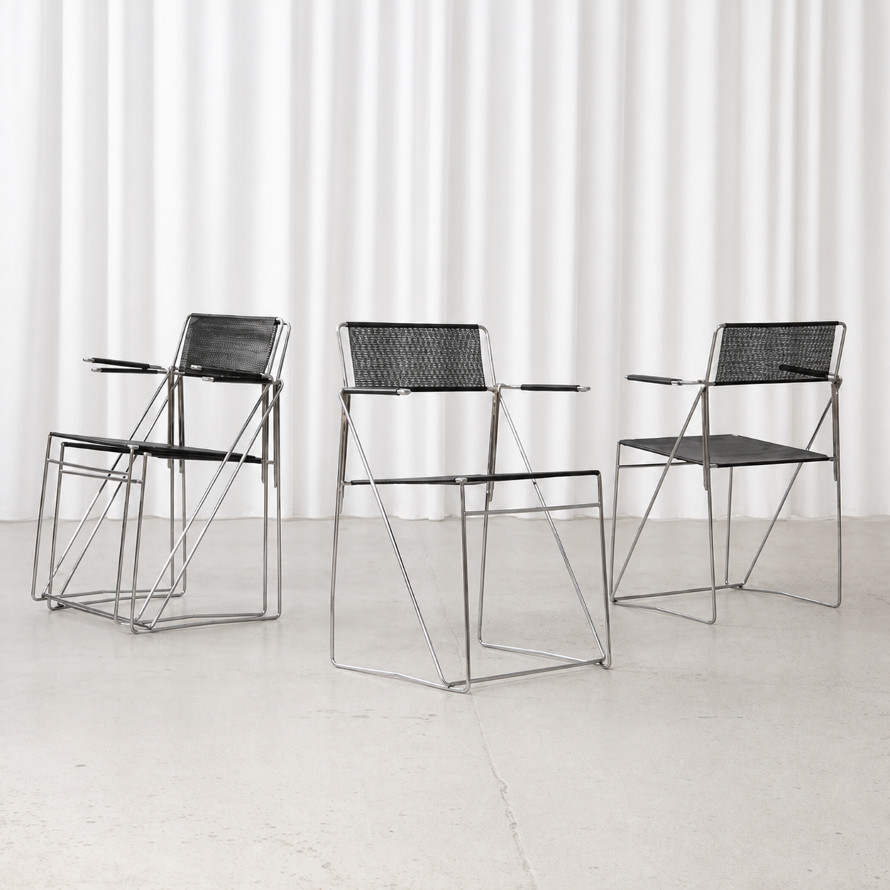 Four Niels Jørgen Haugesen X-Line armchairs in black and chrome