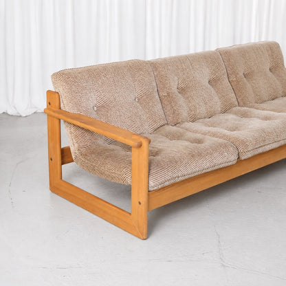 Detail of the pine armrest and buttoned beige upholstery