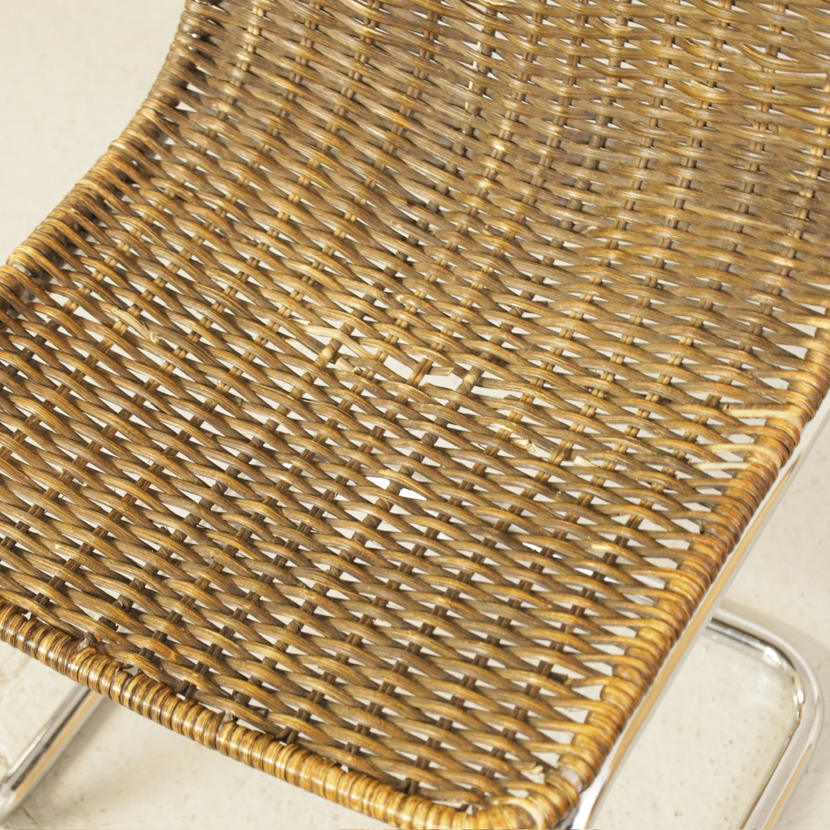 Vintage Italian Chrome and Rattan Cantilever Chair, close-up of woven rattan seat, including damaged strands