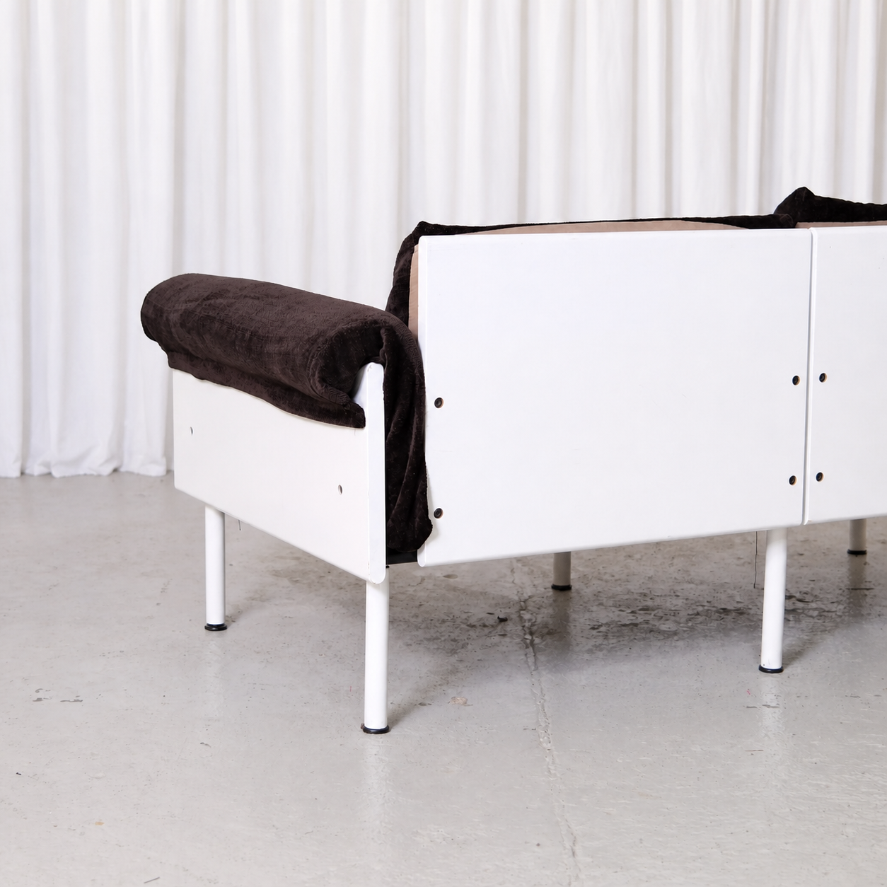 White rear frame and brown velvet arm of Ateljee sofa