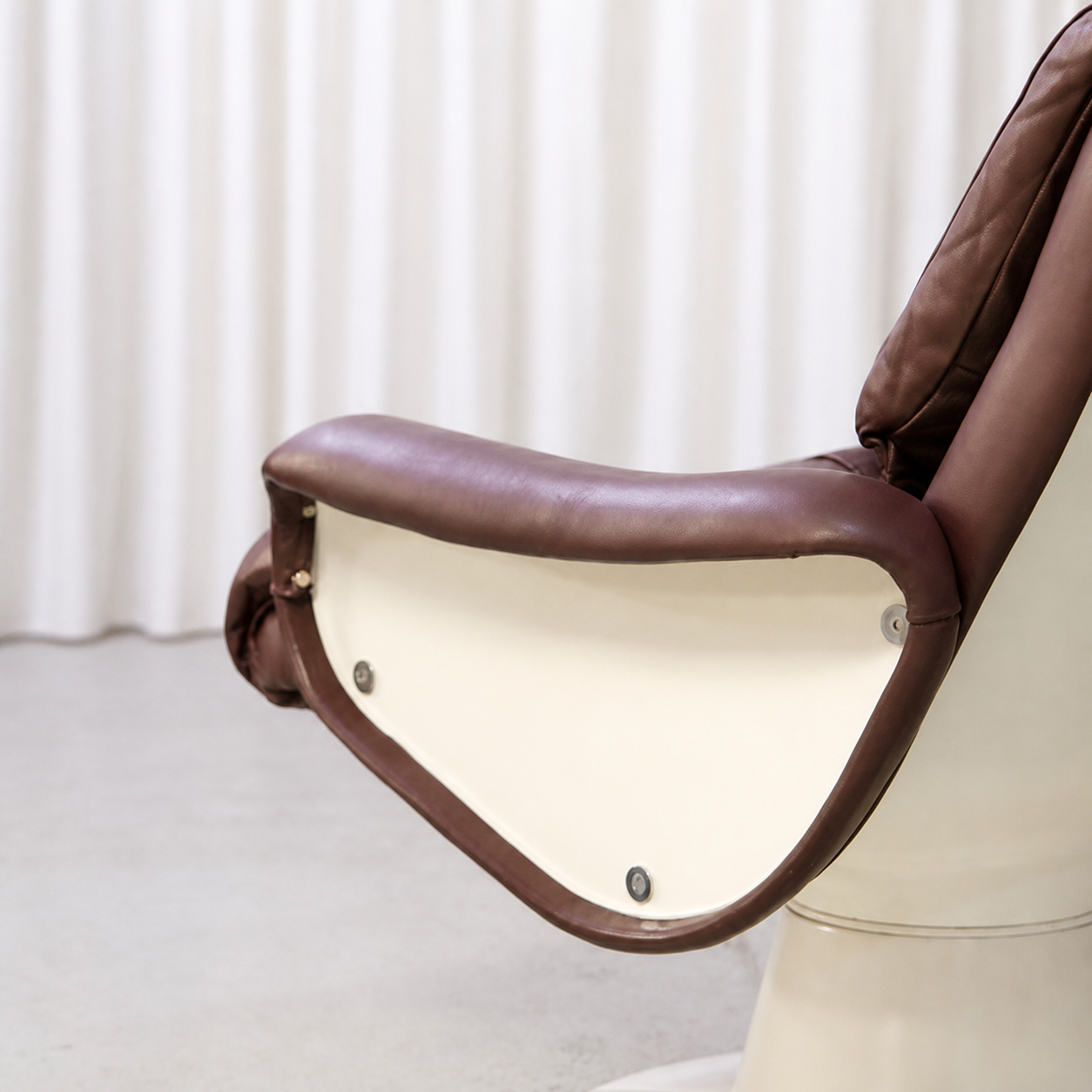 Brown leather armrest and white fibreglass shell detail on Saturnus lounge chair