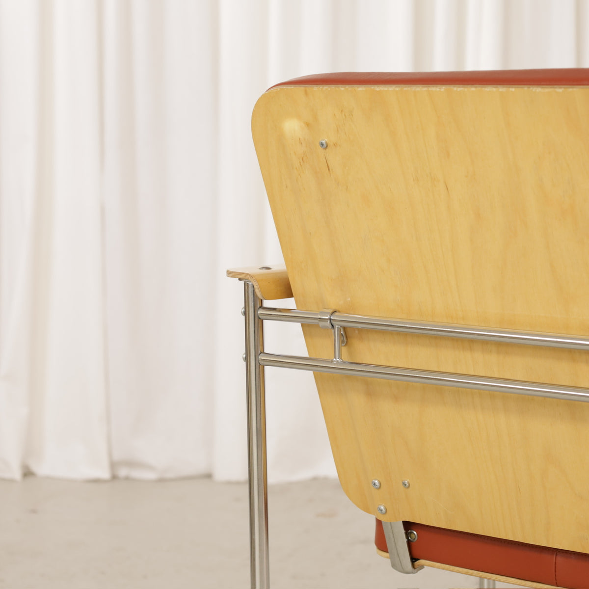 Yrjö Kukkapuro Skaala Armchair in Rust-Red Leather for Avarte, close-up of birch back panel and chromed steel frame
